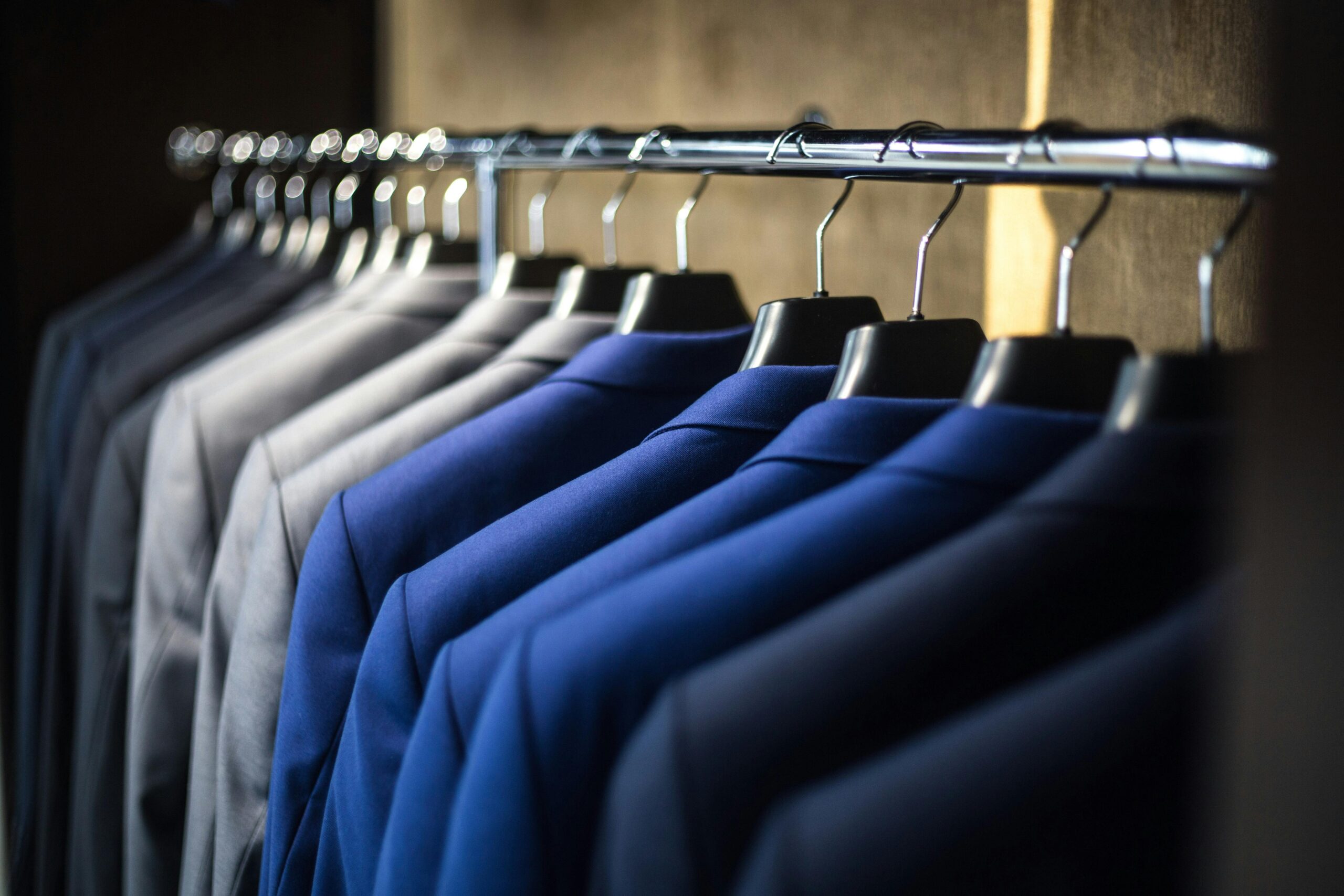 Close-up of neatly arranged suits in a wardrobe, showcasing fashion and organization barang jasa berkualitas